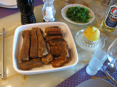 A dish of fried eels for 2 adults flanked with parsley, lemon and a dram
