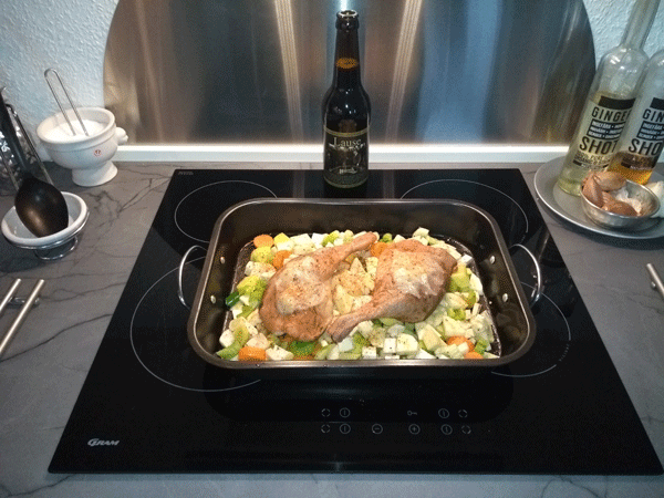 Confit duck leg layered on herbs and root vegetables ready for the oven