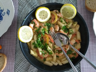 Seithe in bowl in spicy coconut milk with shrimp, bread and herbs 